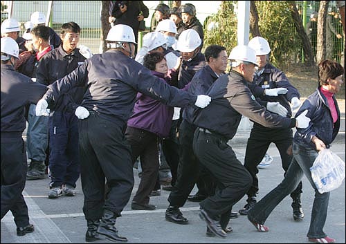 농성 가족들이 '음식물 반입' 불허에 항의하며 공장 안 진입을 시도하고 있다. 